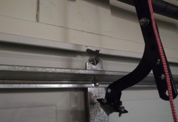New extension spring installed above a steel sectional garage door inside Woodland, CA home after old spring
