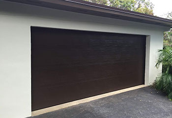 Exterior of Davis, CA home featuring newly installed insulated steel garage door in a contemporary flush wood-tone